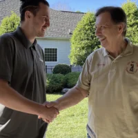 Stair lift customer shaking hands with a manufacturer.