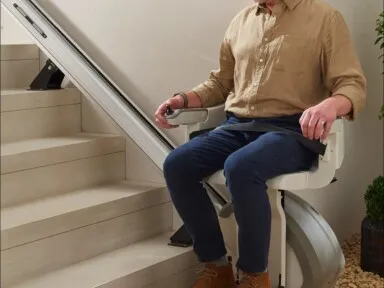nicely dressed handsome older man on outdoor stair lift smiling