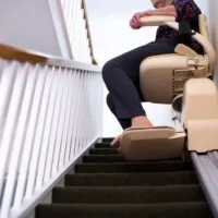 Woman using a stair lift inside of her home.