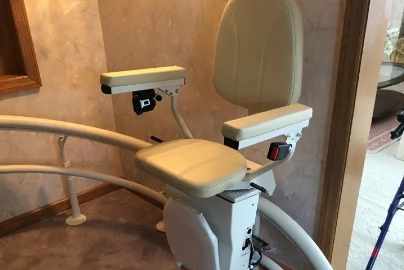 Curved stair lift with beige seat.