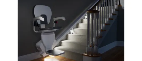 Stair lift against an illuminated stairwell.
