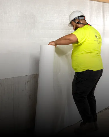 Basement waterproofing being installed in a home