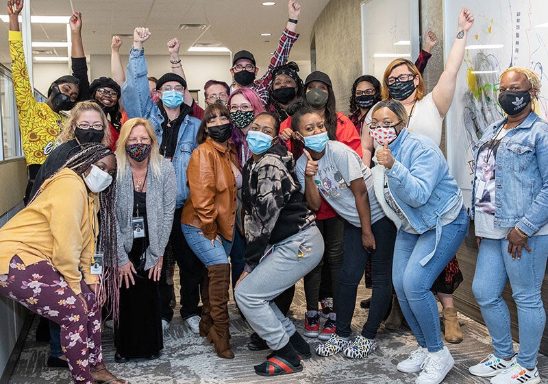 group of happy customers wearing masks at work