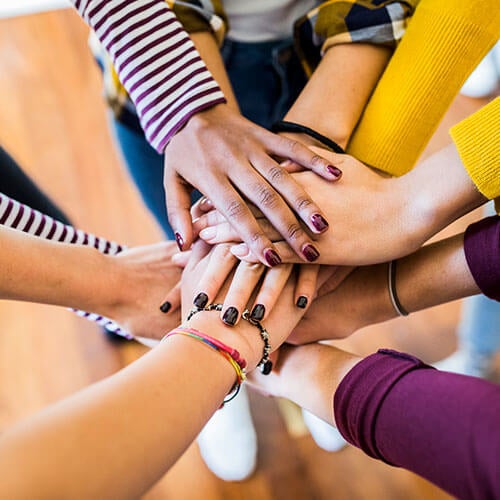 group of hands around a circle of people