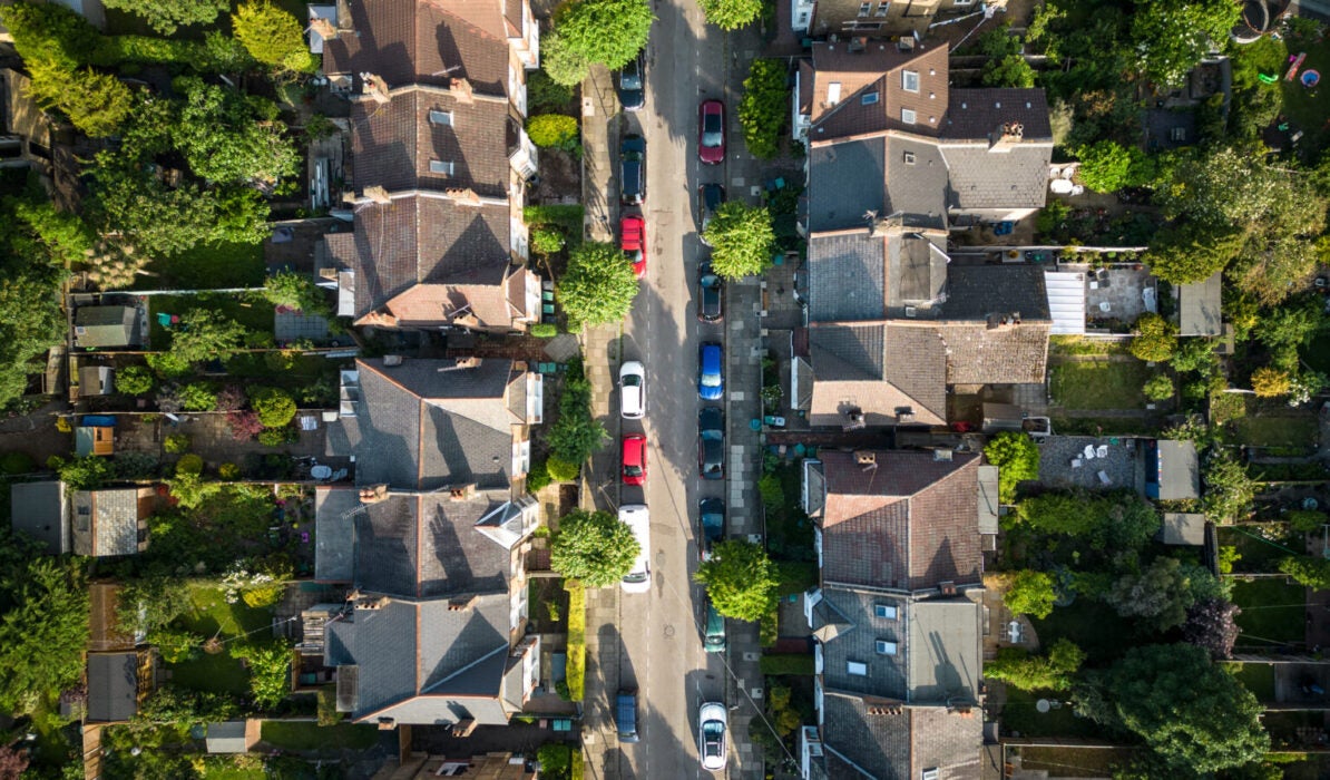 Overhead aerial view of residential homes and road with parked cars
