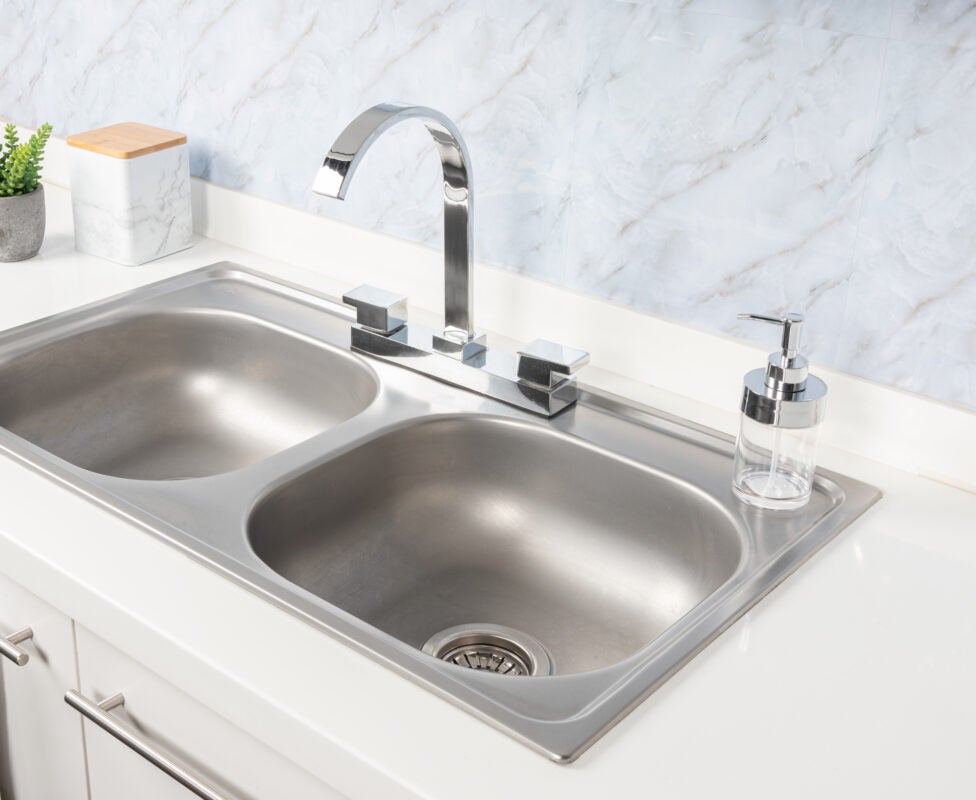 Close up Double Basin Stainless Steel Kitchen Sink and Faucet no water stains